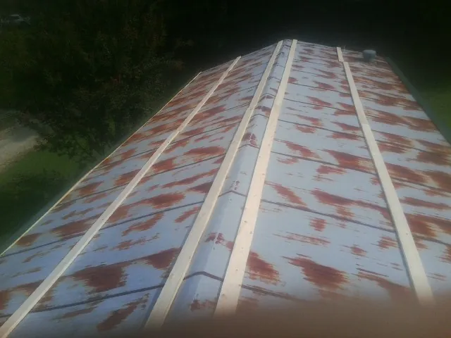 Rusted metal roof panels with new wood purlins before replacement — Storm Damage Roof Repair in Watonga by Roofing Brothers