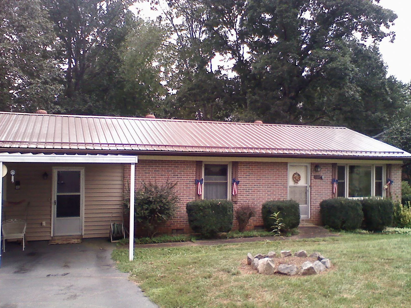 Bronze metal roof and carport on a brick ranch home — Roof Repair work by our crew in Watonga